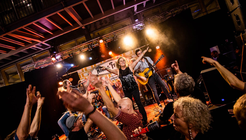 Live optreden op een festival met enthousiast publiek.