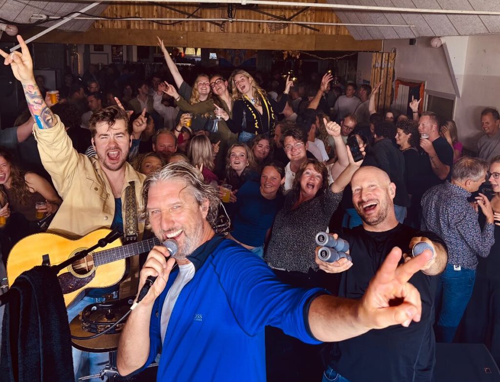 Publiek zingt enthousiast mee tijdens een optreden van Alex & Friends.